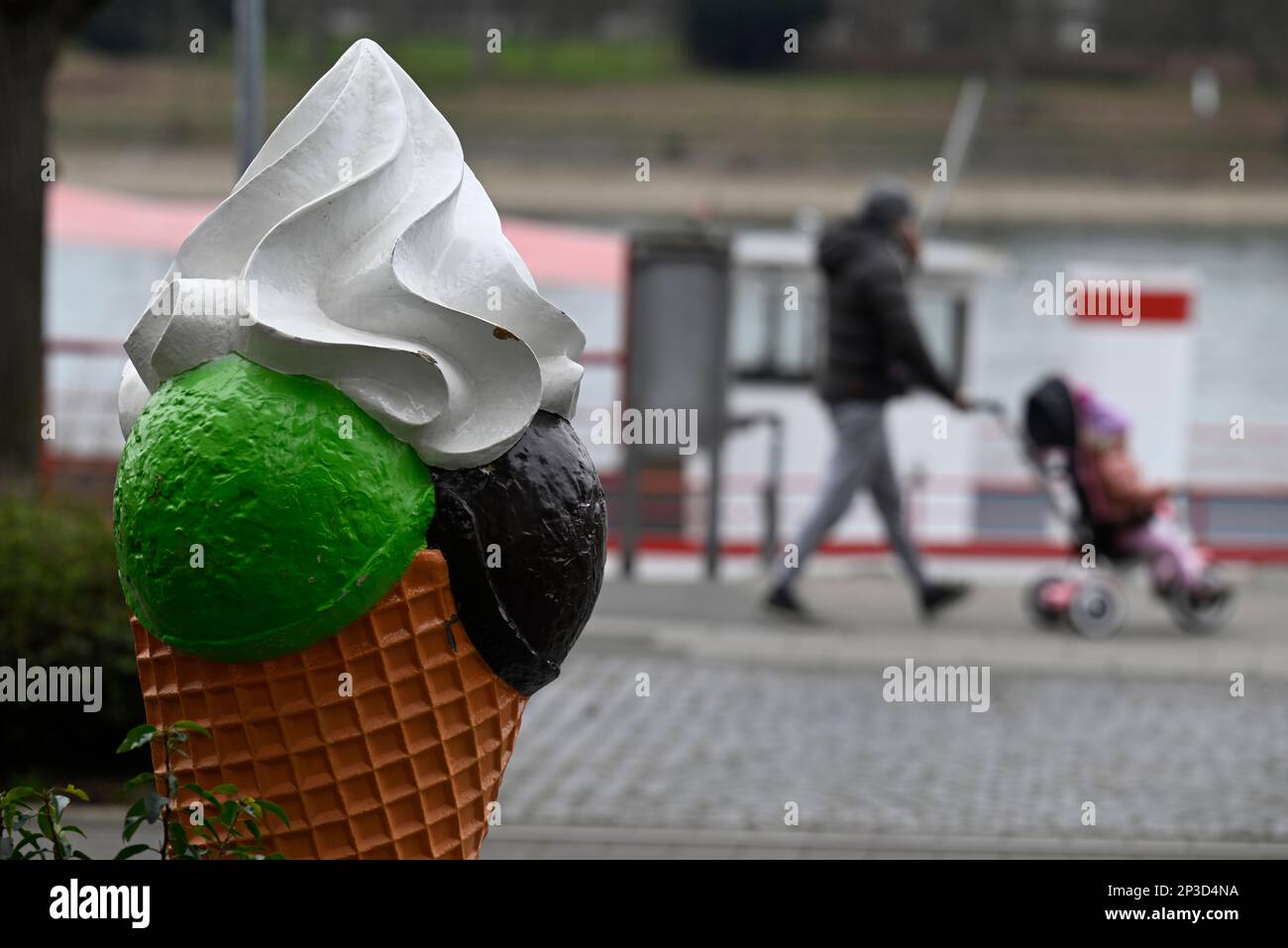 05 mars 2023, Rhénanie-du-Nord-Westphalie, Königswinter : les randonneurs passent une glace surdimensionnée devant un café glacé sur les rives du Rhin. Toutefois, les météorologues prévoient des températures froides avec la pluie pour la semaine suivante. Le printemps est encore loin. Photo: Roberto Pfeil/dpa Banque D'Images