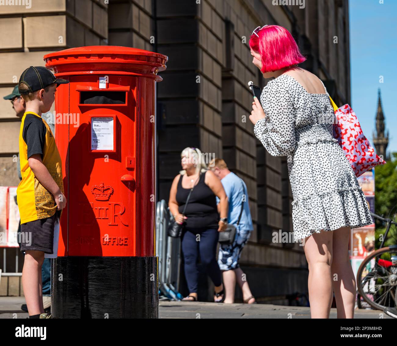 Les gens qui marchent devant et qui sont surpris par une fausse boîte postale parlante pendant le festival Fringe, Royal Mile, Édimbourg, Écosse, Royaume-Uni Banque D'Images