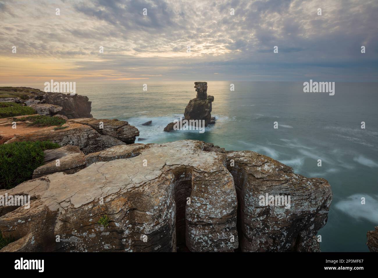 Coucher de soleil derrière la pile de rochers à Cabo Carvoeiro avec la mer orageux, Peniche, région centrale, Portugal, Europe Banque D'Images