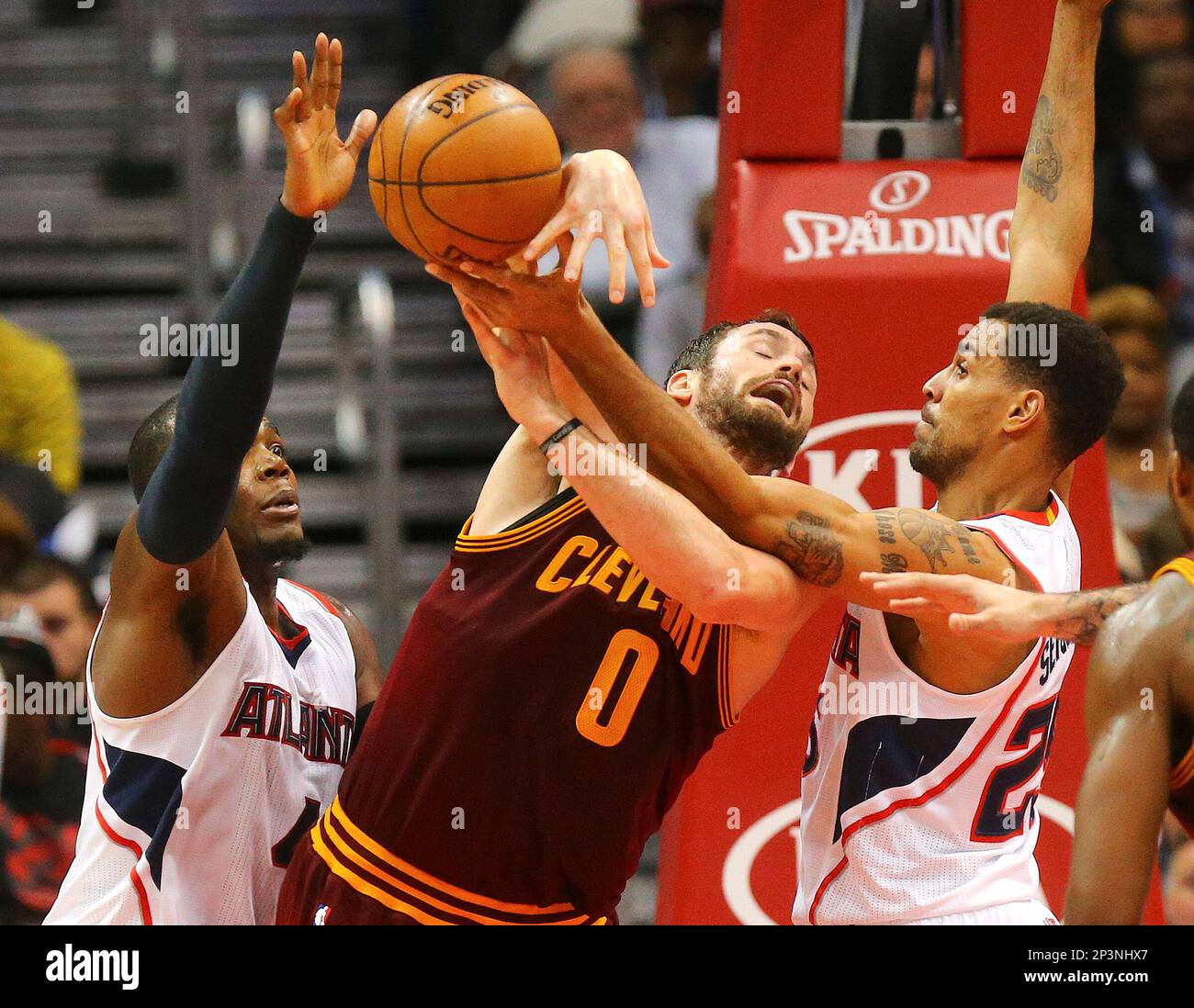 Cleveland Cavaliers' Kevin Love, center, loses the ball while defended by Atlanta Hawks' Paul Millsap, left, and teammate Thabo Sefolosha, of Switzerland, in the second quarter of an NBA basketball game, Tuesday, Dec. 30, 2014, in Atlanta. (AP Photo/Atlanta Journal-Constitution, Curtis Compton) Banque D'Images