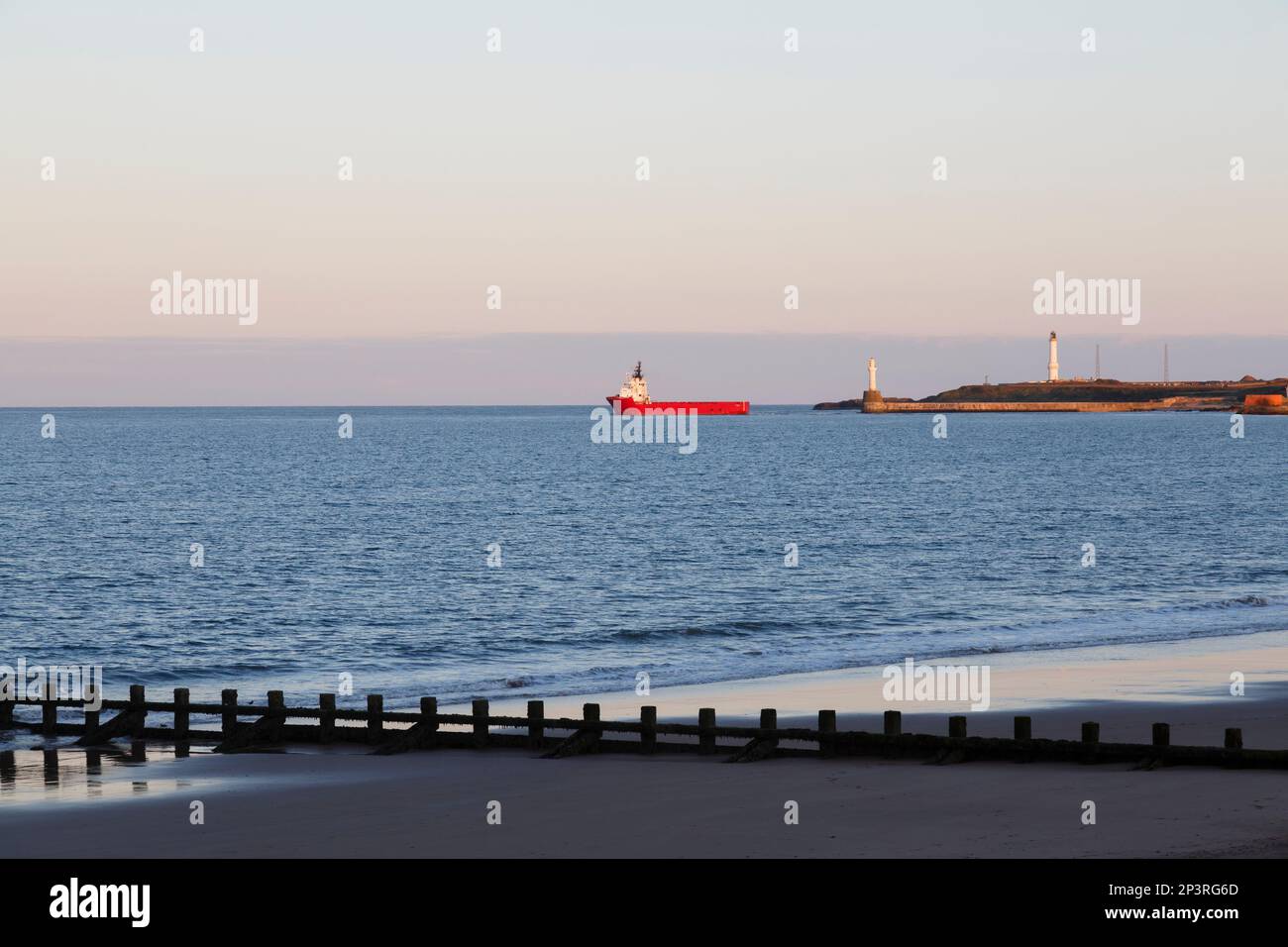 Bateau naviguant depuis Aberdeen Harbour au crépuscule, en Écosse, au Royaume-Uni, en Europe Banque D'Images