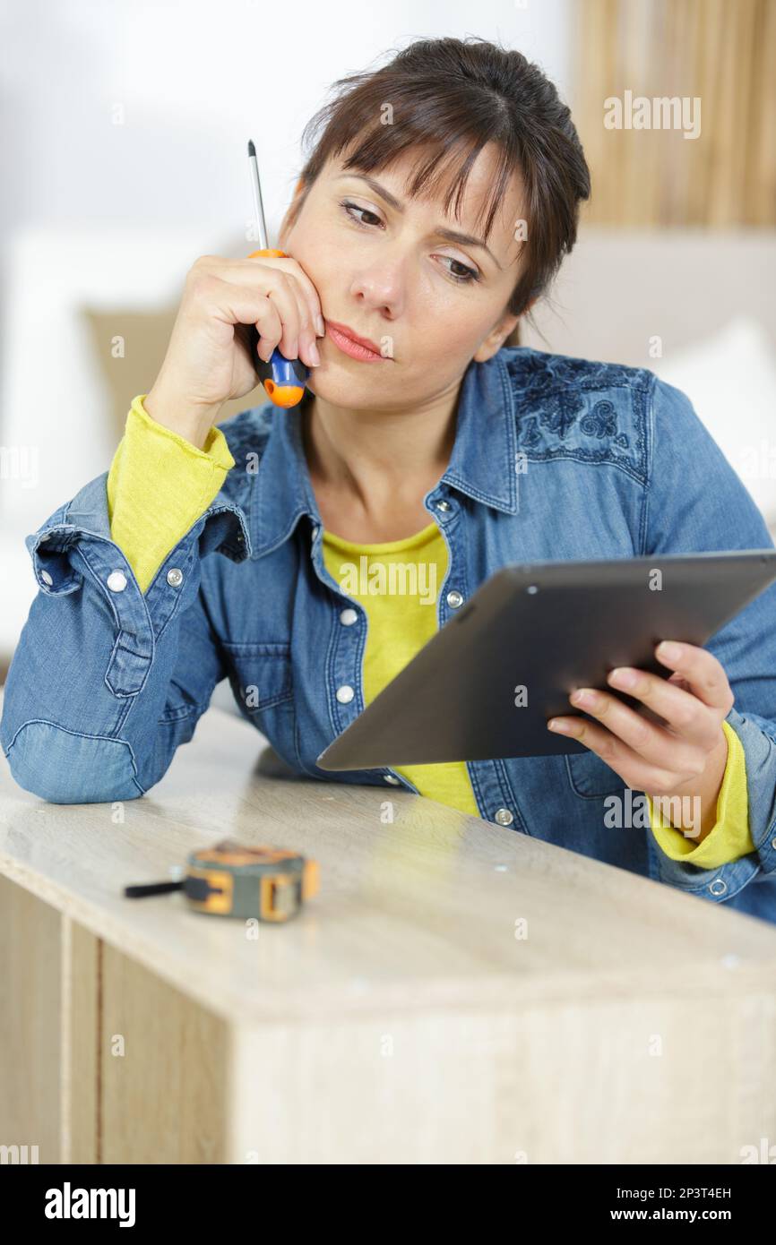 femme utilisant une tablette pour fixer des pièces de meubles Photo Stock -  Alamy