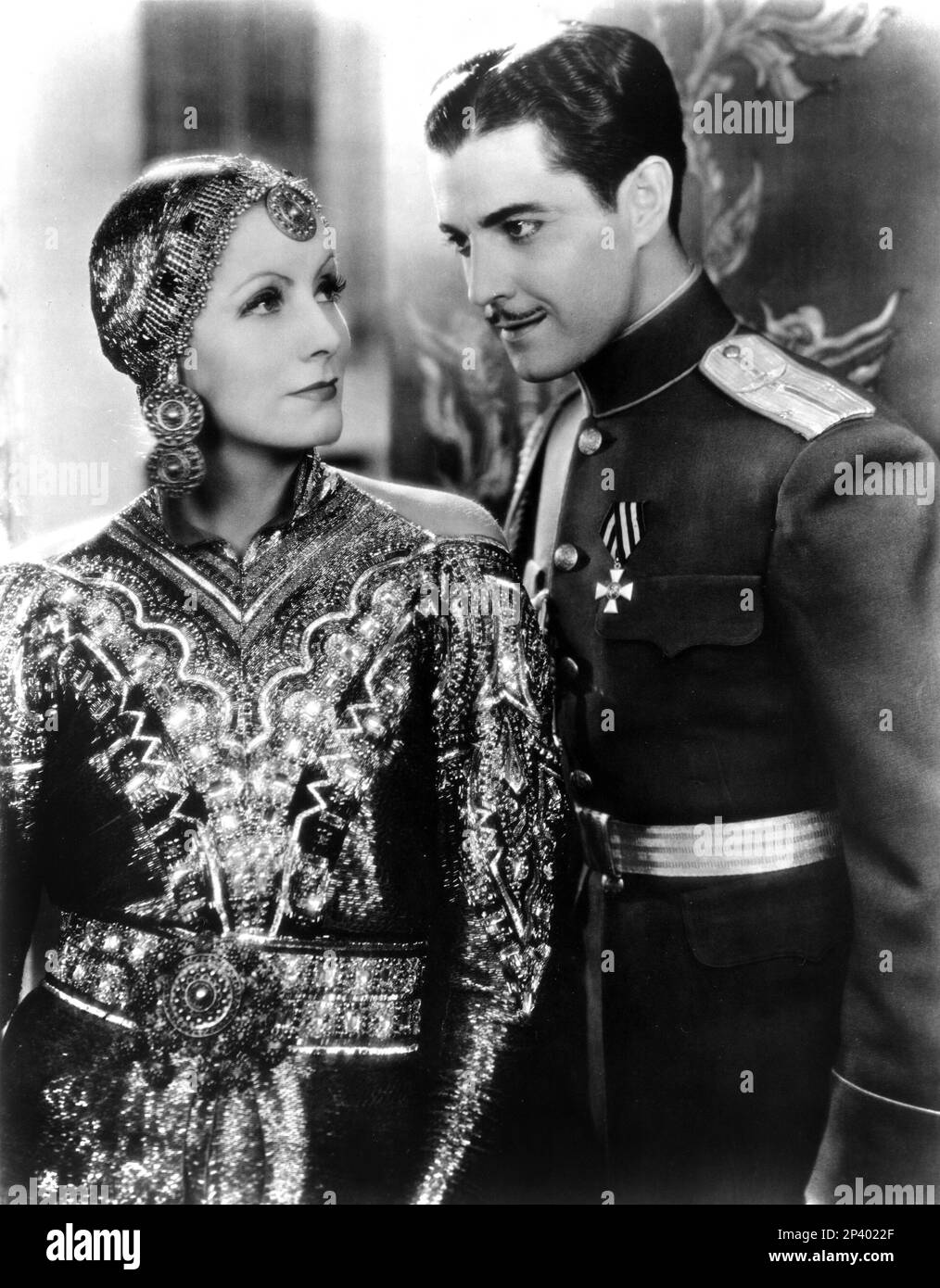 1932 : l'actrice GRETA GARBO avec RAMON NOVARRO à MATA HARI par Edmund Goulding , D'un roman de Vicki Baum - MGM - FILM - FILM - CINÉMA - portrait - ritrato - diva - divina - divin - spia - espion - chapeau - cappello - boucles d'oreilles - gouttes d'oreille - orecchini - orecchino - bjioux - gioiello - gioielli - bijoux - Mistrero - mystère - baffi - moustache - uniforme divisa militare --- Archivio GBB Banque D'Images