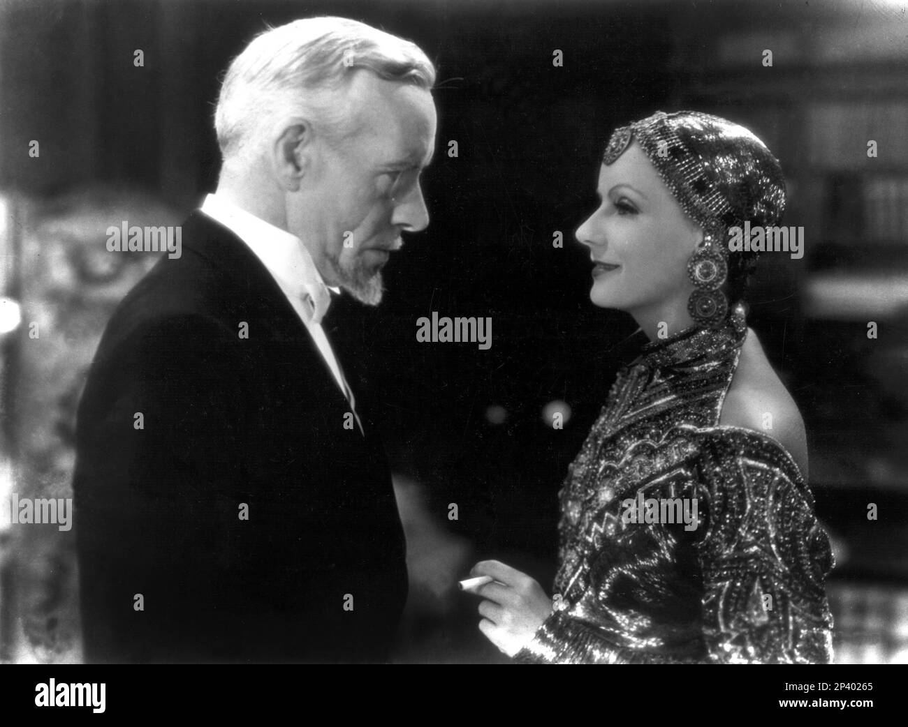 1932 : l'actrice GRETA GARBO avec LEWIS STONE à MATA HARI par George Fitzmaurice , D'un roman de Vicki Baum - MGM - FILM - FILM - CINÉMA - portrait - ritratto - diva - divina - divin - spia - espion - chapeau - cappello - mistero - mystère - sigaretta - cigarette - personalità celeità la fuma - fumatore - personnalité de la célébrité Personnalités célébrités fumeurs - profilo - profil - innamorati - amanti - amanti - amants --- Archivio GBB Banque D'Images
