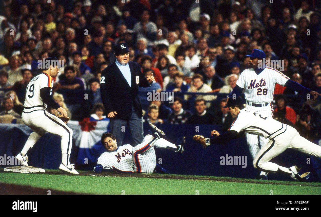 Houston Astros first baseman Glenn Davis leaps to tag New York Mets' Wally Backman as Bill Duran covers first base. Umpire Joe West calls interference on Astros pitcher Mike Scott in Game 4 of the National League Championship Series, Tuesday, Oct. 12, 1986, in New York. Backman was safe. (AP Photo/Kathy Kmonicek) Banque D'Images