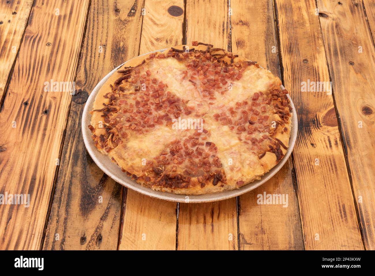 Une curieuse pizza au plat profond avec du fromage et beaucoup de bacon frit et des tacos à l'oignon Banque D'Images