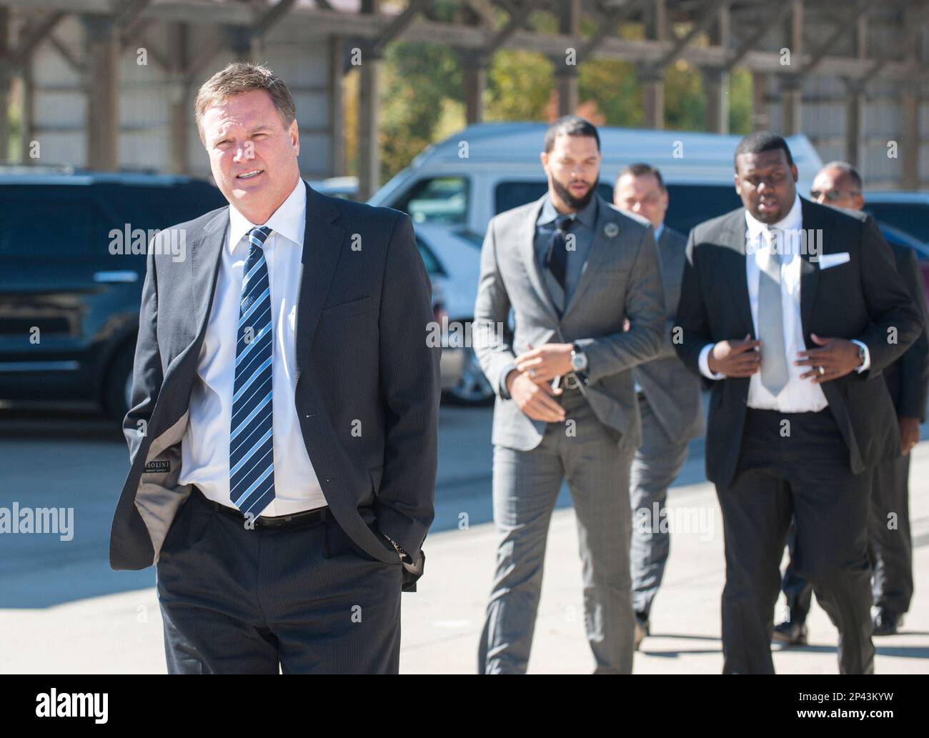 Kansas basketball coach bill self walks ahead of nba basketball player