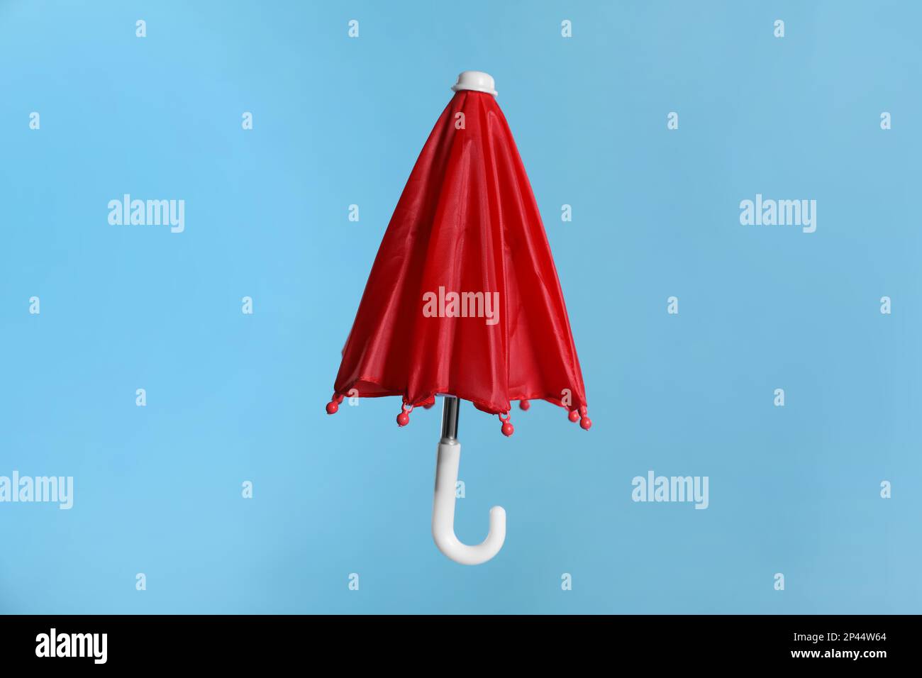 Petit parapluie rouge fermé sur fond bleu clair Photo Stock - Alamy