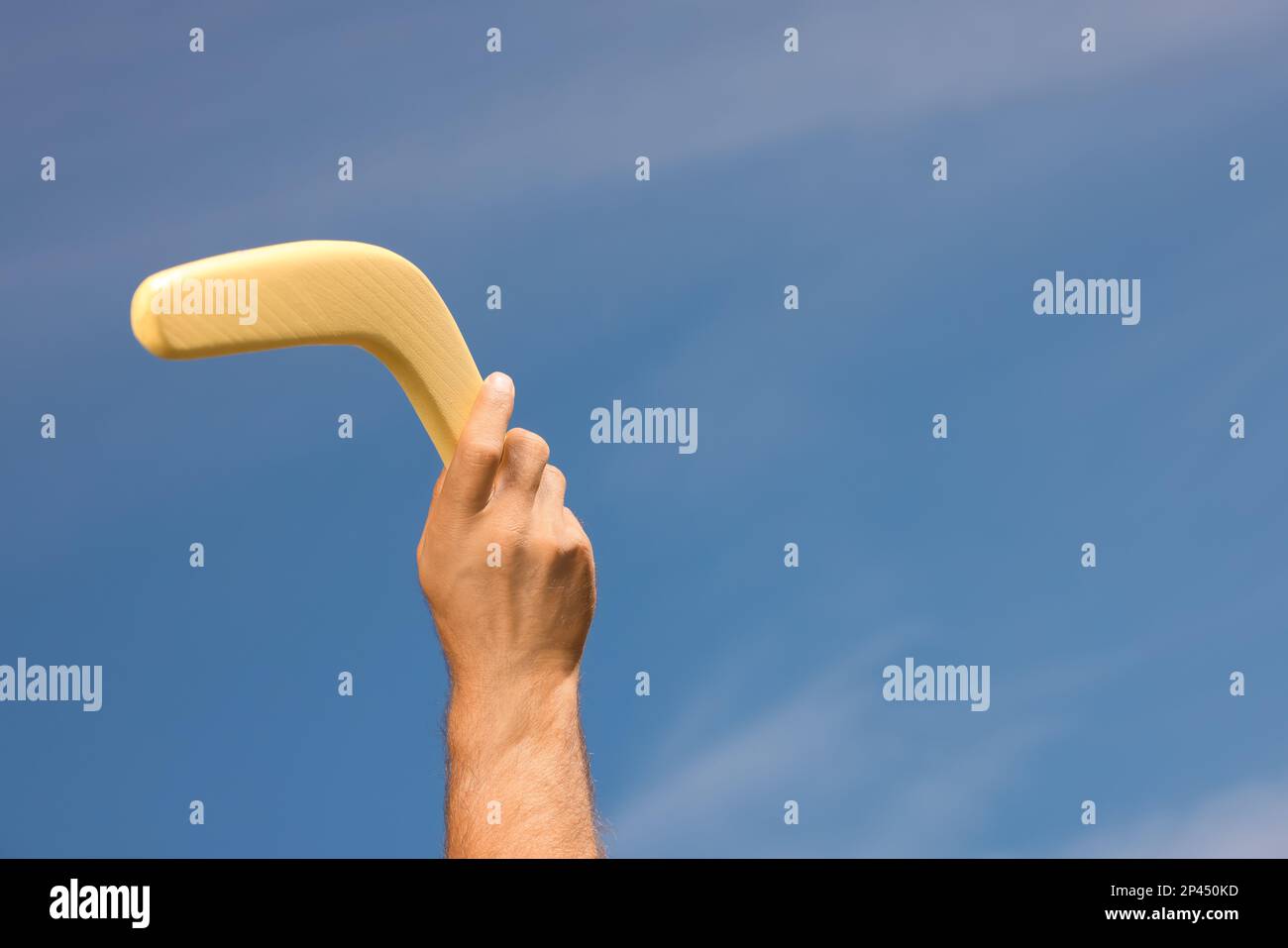 Homme lançant boomerang contre le ciel bleu, gros plan. Espace pour le texte Banque D'Images
