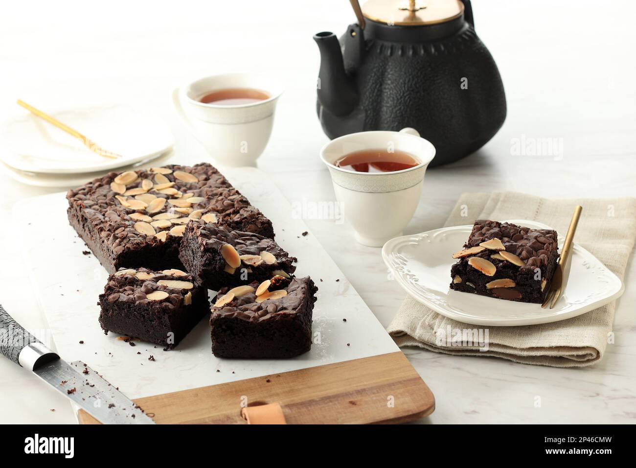 Brownies au chocolat fudgy maison sur fond de table blanche, servies avec du thé. Gâteau au chocolat et à l'amande Brownie Still Life Banque D'Images