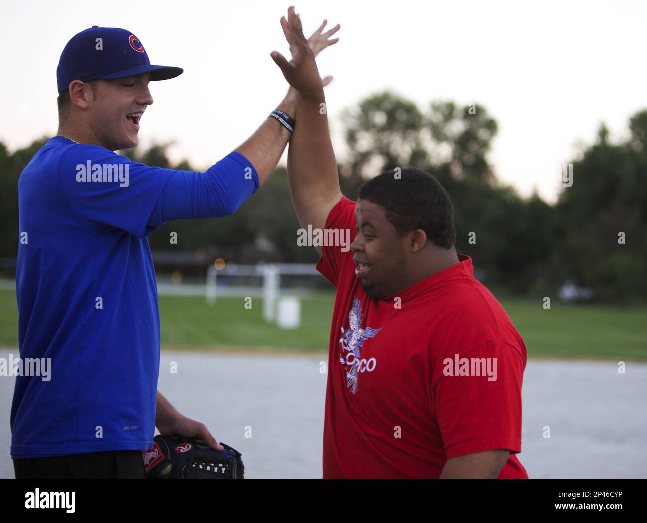 Jordan Minch celebrates with Munster Challengers player Tevin Allen. Minch surprised the special needs softball team on his two-day visit home before leaving for Mesa, Arizona, on assignment. He signed autographs, took photos, answered questions and did what he knows best — took to the mound. Minch pitched softballs to Challenger players for about an hour. (AP Photo/The Times, Damian Rico) Banque D'Images