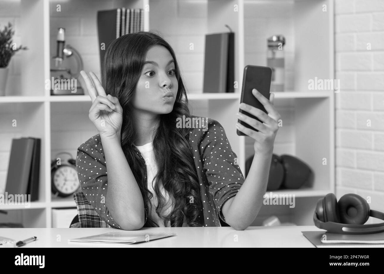 drôle de jeune fille de faire la vidéo sur selfie en utilisant le téléphone mobile montrant le geste de paix, blogging Banque D'Images