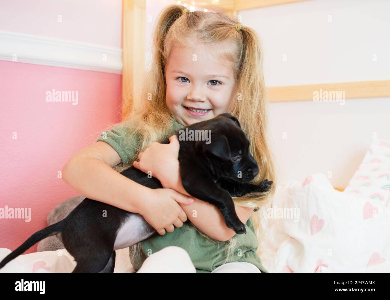 Bonne petite fille du Caucase avec un chiot. Chien de garde d'enfant. Concept PET. Enfant souriant Banque D'Images