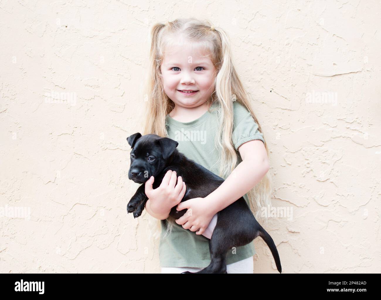 Bonne petite fille du Caucase avec un chiot. Chien de garde d'enfant. Concept PET. Enfant souriant Banque D'Images