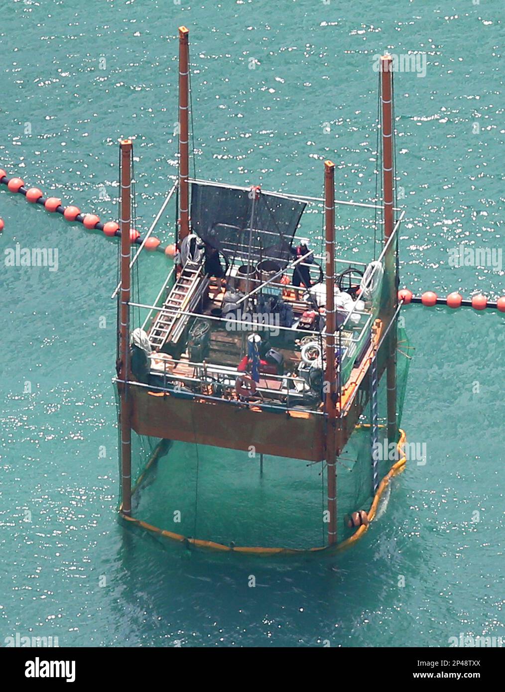 A photo taken from Yomiuri's jetliner shows the Defense Ministry's offshore drilling survey of the seafloor starting at the barge off the Henoko destrict of Nago, Okinawa Prefecture on Aug. 18, 2014. The site will be the planned relocation site for the U.S. Futenma airbase and the ministry will complete the drilling survey by the end of November. ( The Yomiuri Shimbun via AP Images ) Banque D'Images