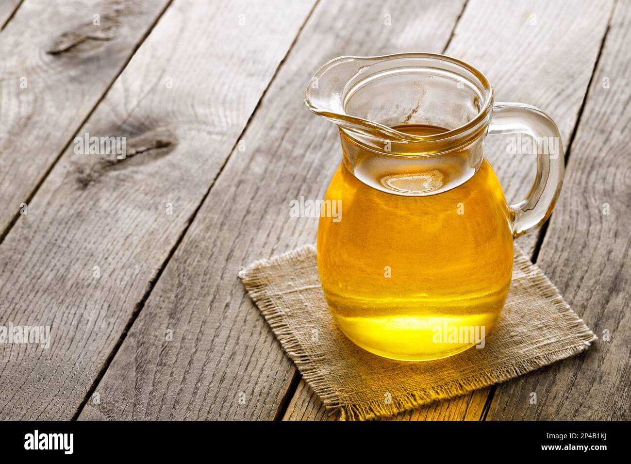 huile de cuisson dans une verseuse en verre sur une table en bois Banque D'Images