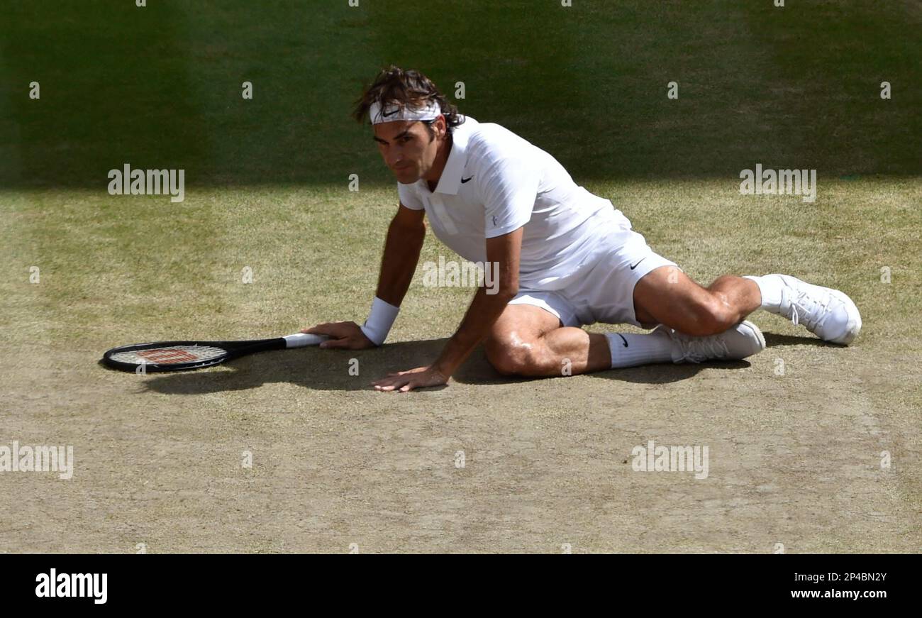 Roger Federer of Switzerland slips over on the court as he plays against Novak Djokovic of Serbia during their men's singles final match at the All England Lawn Tennis Championships at Wimbledon, London, Sunday, July, 6, 2014. (AP Photo/Toby Melville, Pool) Banque D'Images