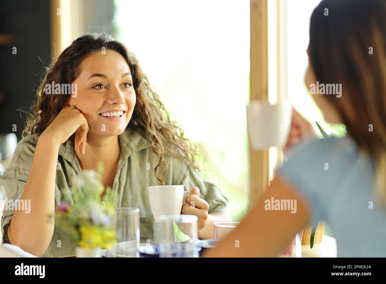 Deux amis qui parlent au petit déjeuner et qui boivent du café dans un restaurant Banque D'Images