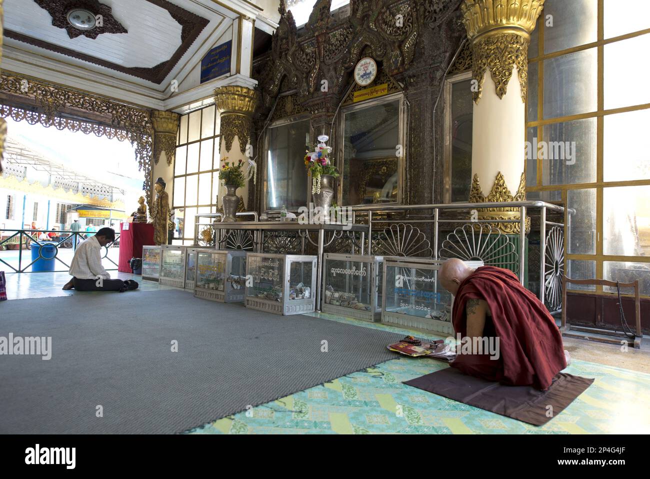 Monk avec tatouage priant dans le temple, Yangon, Myanmar Banque D'Images