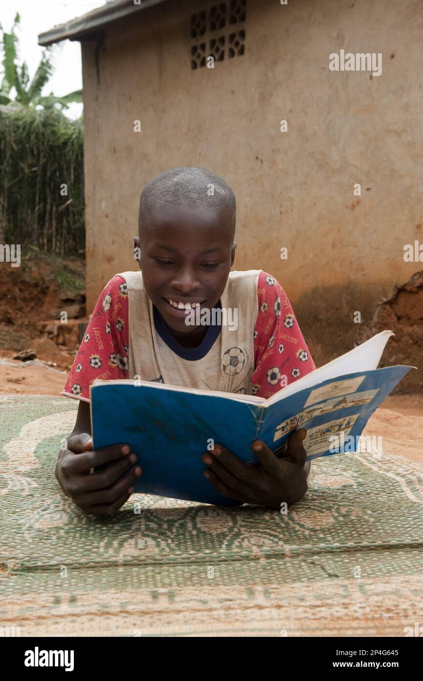 Enfants lisant un manuel à la maison, Rwanda Banque D'Images