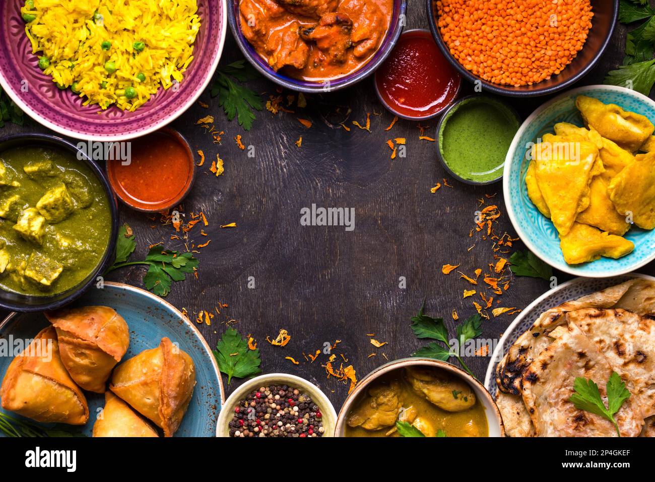 Assortiment de plats indiens sur fond de bois sombre. Plats de cuisine indienne. Curry, beurre de poulet, riz, lentilles, paneer, samosa, naan, chutney Banque D'Images