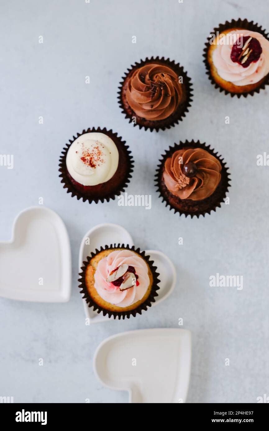 Délicieux chocolats, velours rouge, petits gâteaux à la framboise aux coeurs blancs Banque D'Images