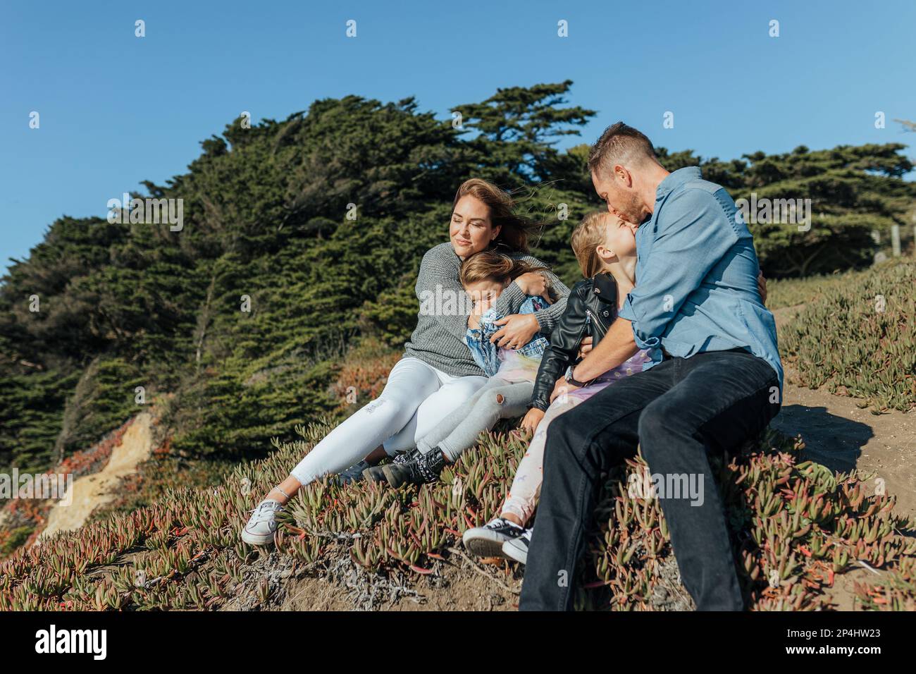 Famille se blottir et s'asseoir dans la nature Banque D'Images