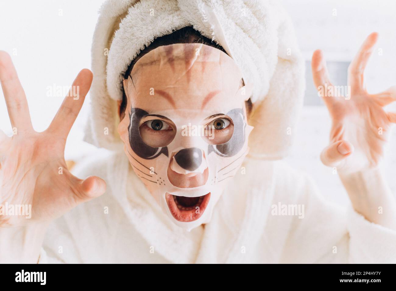 Une fille qui se berce dans un masque en tissu sous la forme d'un tigre sur le visage Banque D'Images