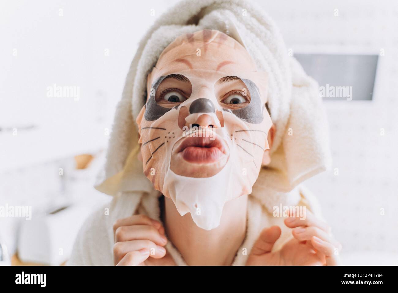 Femme qui se berce dans un masque en tissu sous la forme d'un tigre sur le visage Banque D'Images