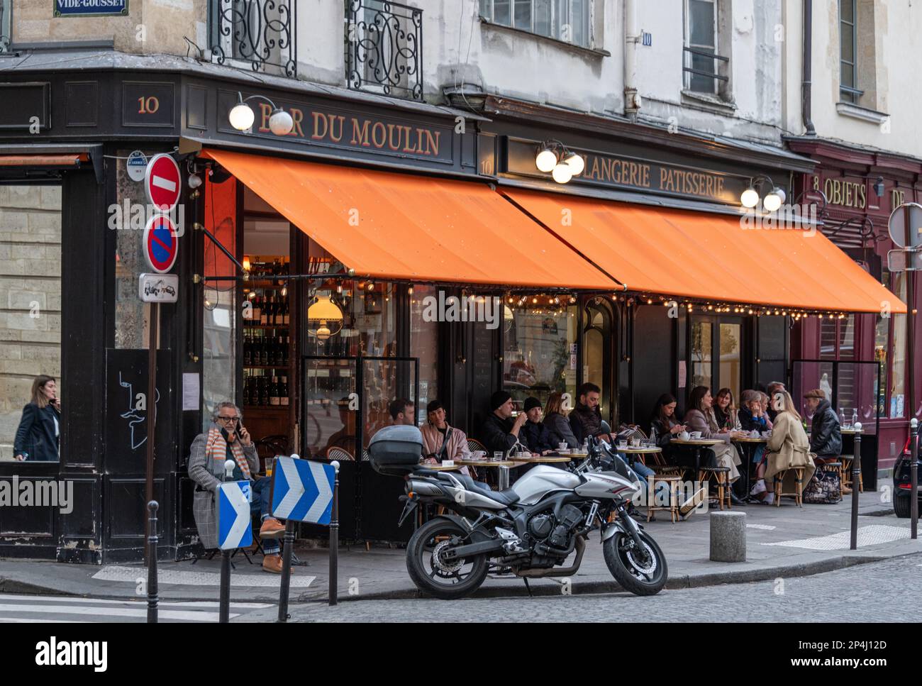 Personnes assises à l'extérieur du Bar Moulin dans le 3rd arrondissement de Paris Banque D'Images