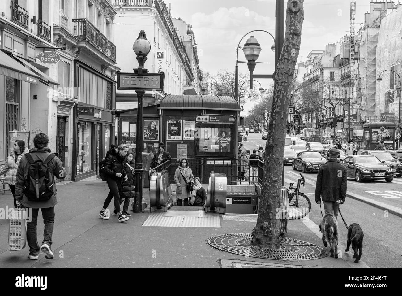 Les gens marchent vers et de et après l'entrée de la station de métro Grand Boulevard sur le boulevard Poissonnière, 2nd arrondissement de Paris. Banque D'Images