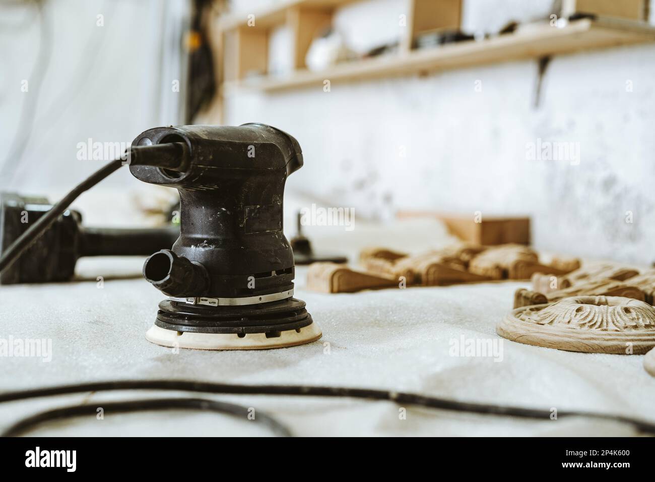 Rectifieuse électrique manuelle pour le travail du bois sur la table dans l'atelier de menuisier Banque D'Images