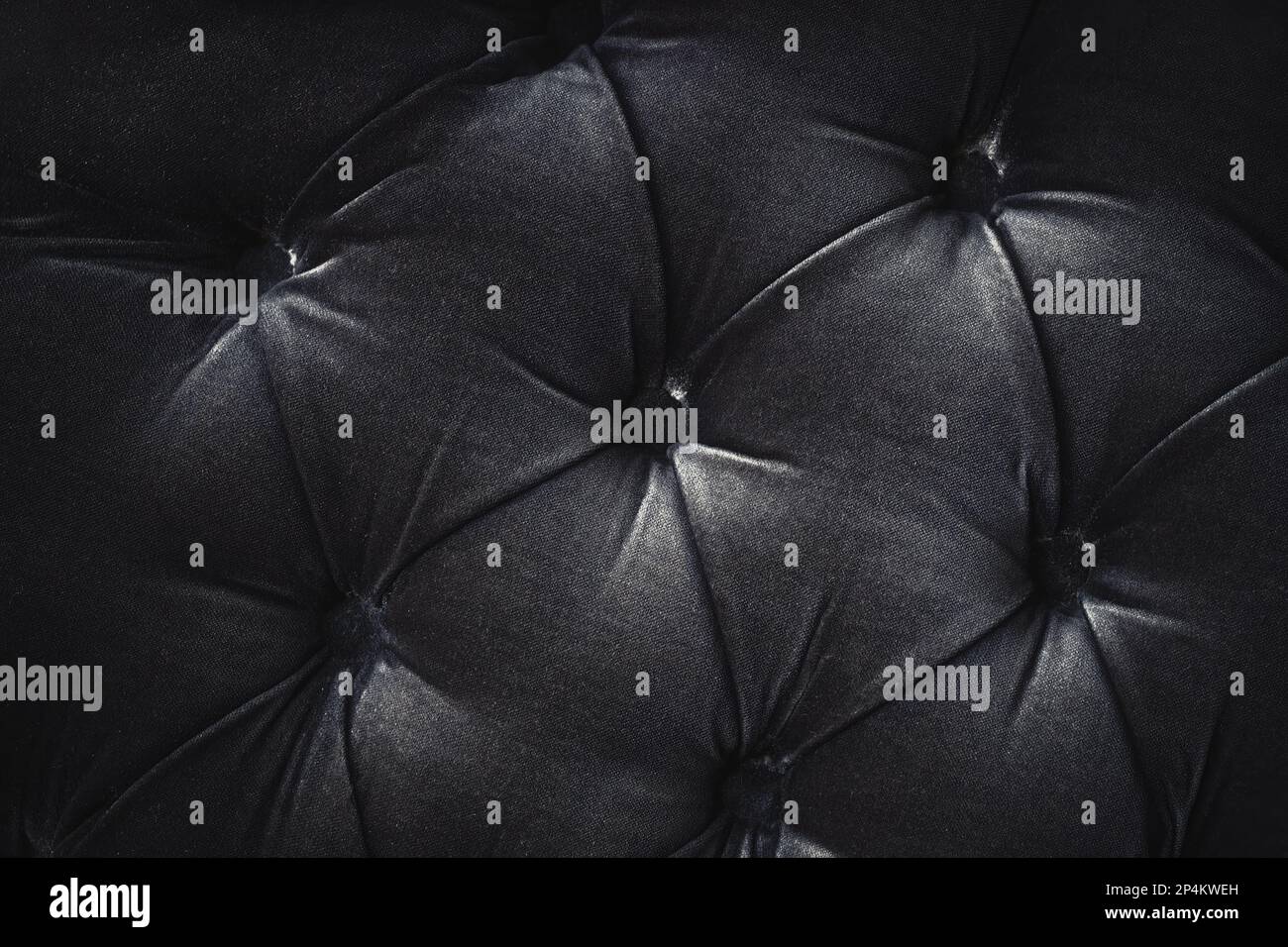 Coussin en matériau noir touffeté, motif abstrait, arrière-plan avec boutons Banque D'Images