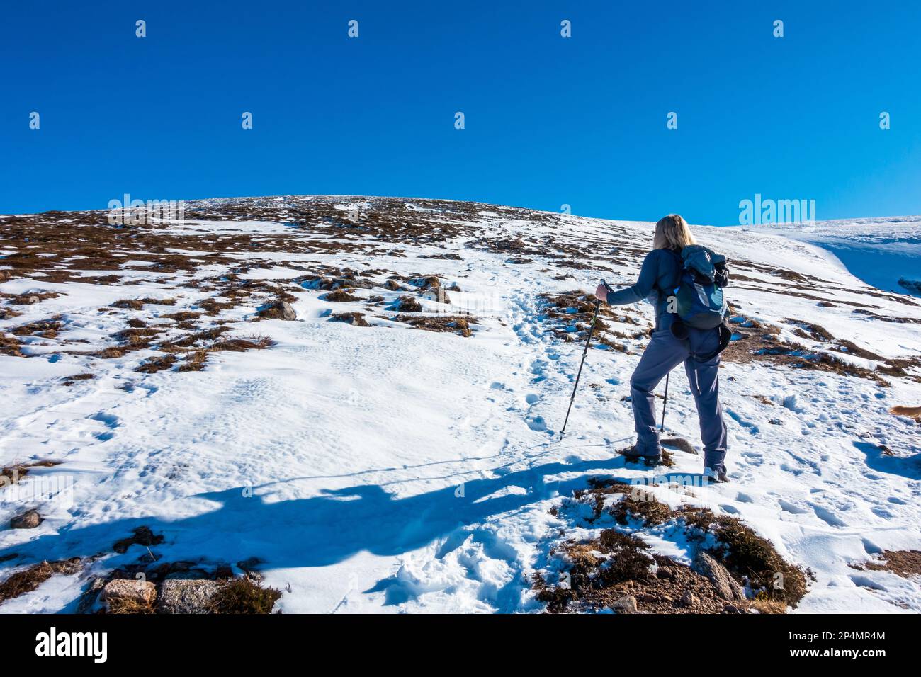 Un marcheur sur le chemin de la montagne Scottish Munro de Sgor Gaoith en hiver Banque D'Images