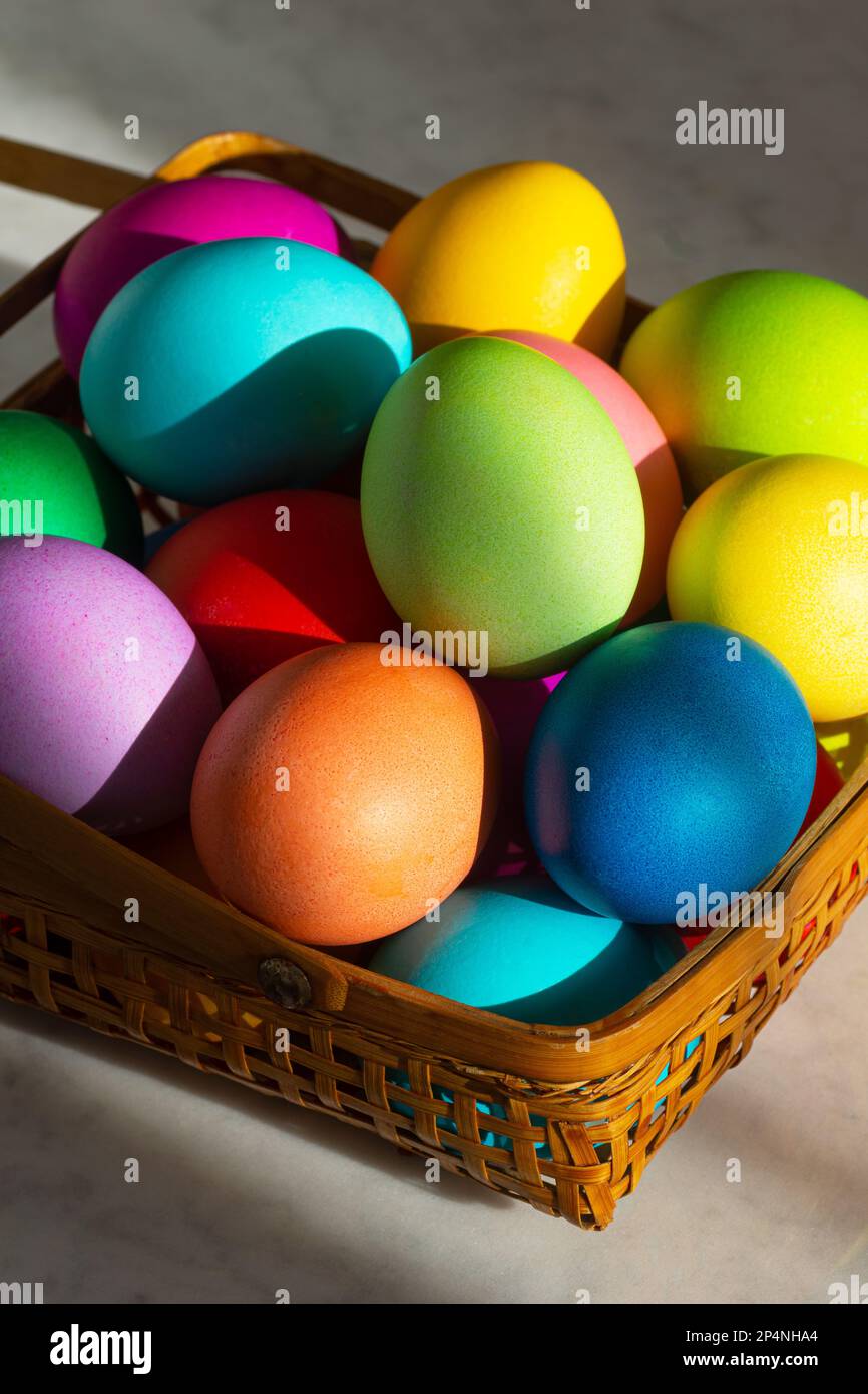 Panier rempli d'œufs de Pâques colorés en couleurs arc-en-ciel pour les vacances de printemps Banque D'Images