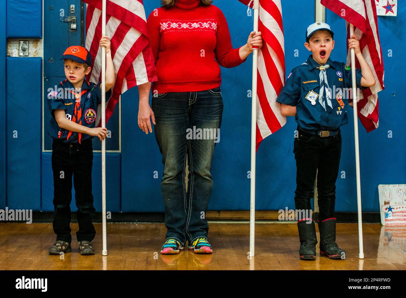Henderson, Mich., residents Jack Livingston, 6, left, waits for soldiers' arrival while his brother Evan, 8, yawns while the two hold American flags in a line to greet more than 150 Michigan Army National Guard soldiers of the 144th Military Police Company return home from Afghanistan on Thursday, Jan. 23, 2014, at Owosso High School in Owosso, Mich. (AP Photo/The Flint Journal, Jake May) LOCAL TV OUT; LOCAL INTERNET OUT. Banque D'Images
