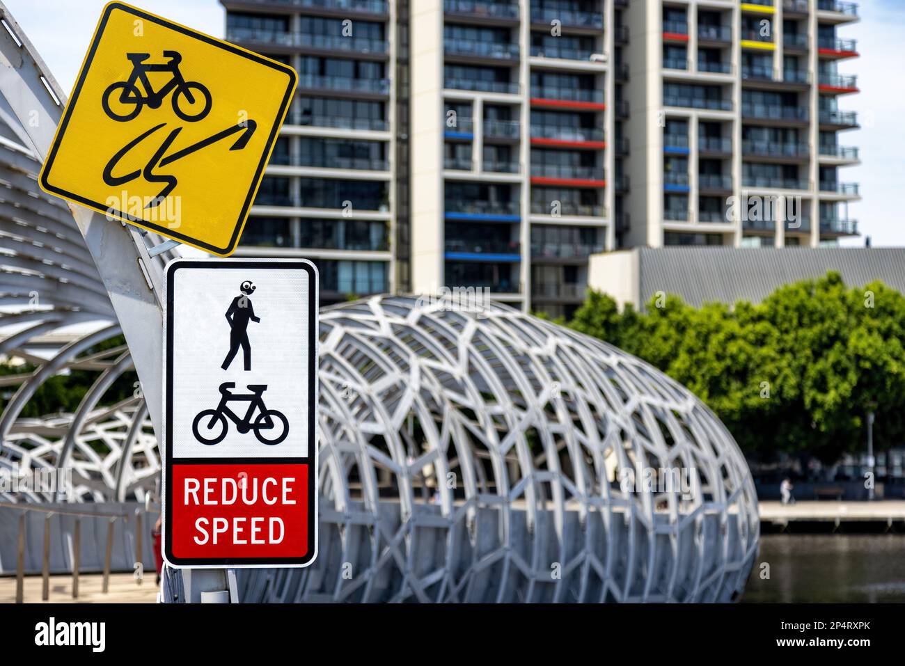Pont webb de Melbourne traversant la Yarra River, avec des instructions pour les cyclistes de réduire la vitesse et d'être au courant des piétons. Quelqu'un a ajouté un oeil de googly Banque D'Images