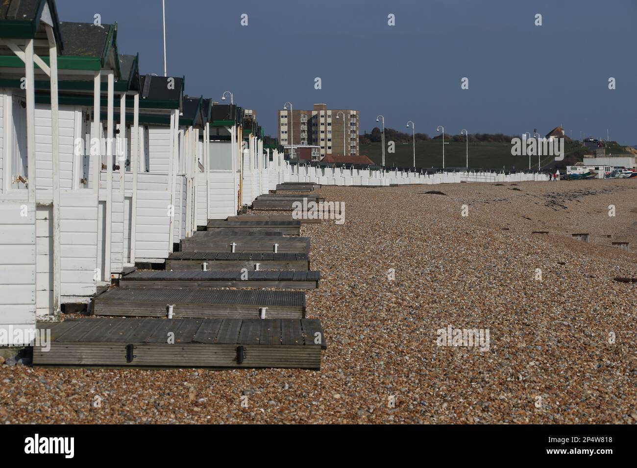 une longue ligne de cabanes de plage sur la côte du sussex Banque D'Images