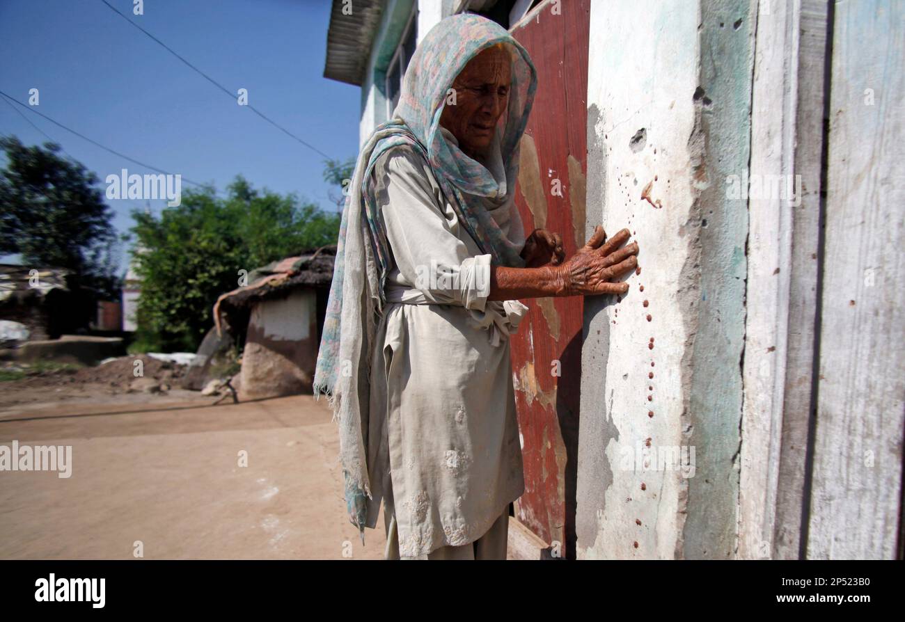 Bero Devi touches blood stains on a wall of her bullet-riddled home in ...