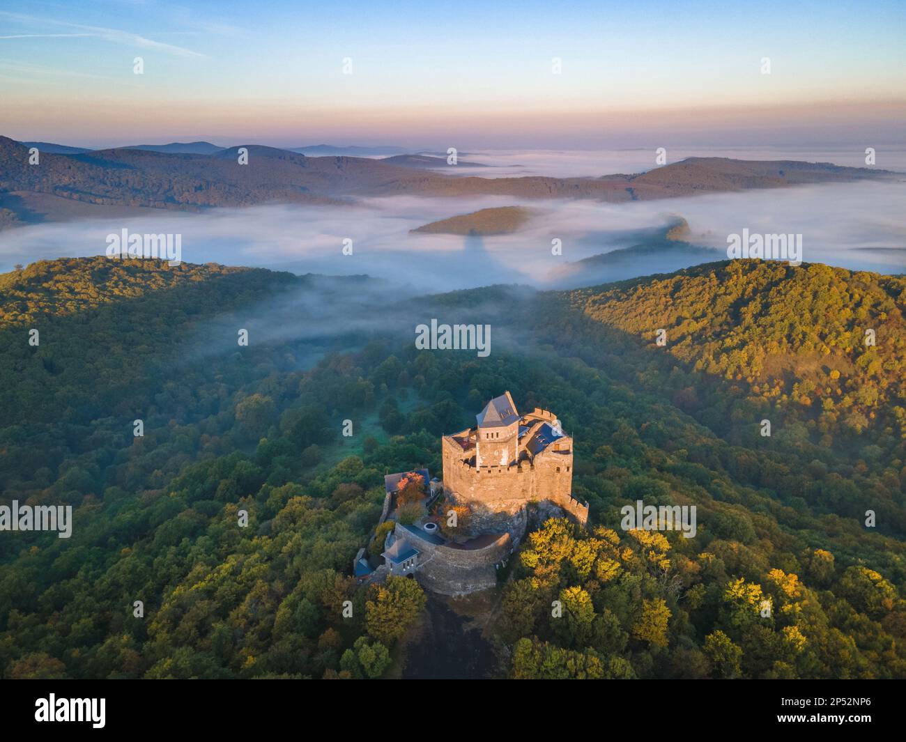 Vue aérienne du château de Hollókő magnifiquement rénové et des collines idylliques de Cserhát couvertes de brouillard Banque D'Images