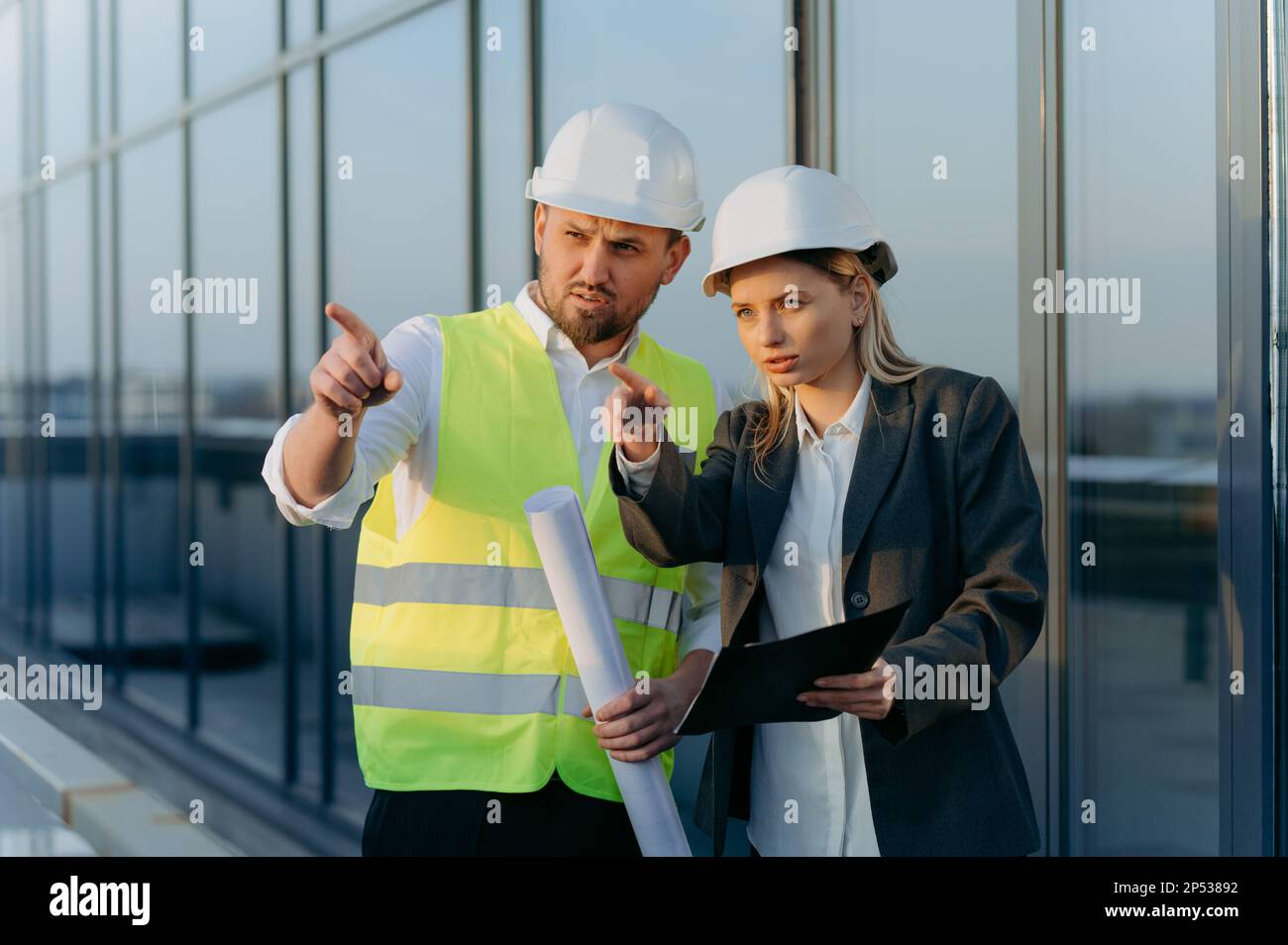 l'architecte montre à l'ingénieur le travail terminé. homme et femme parlant près d'un bureau en verre Banque D'Images