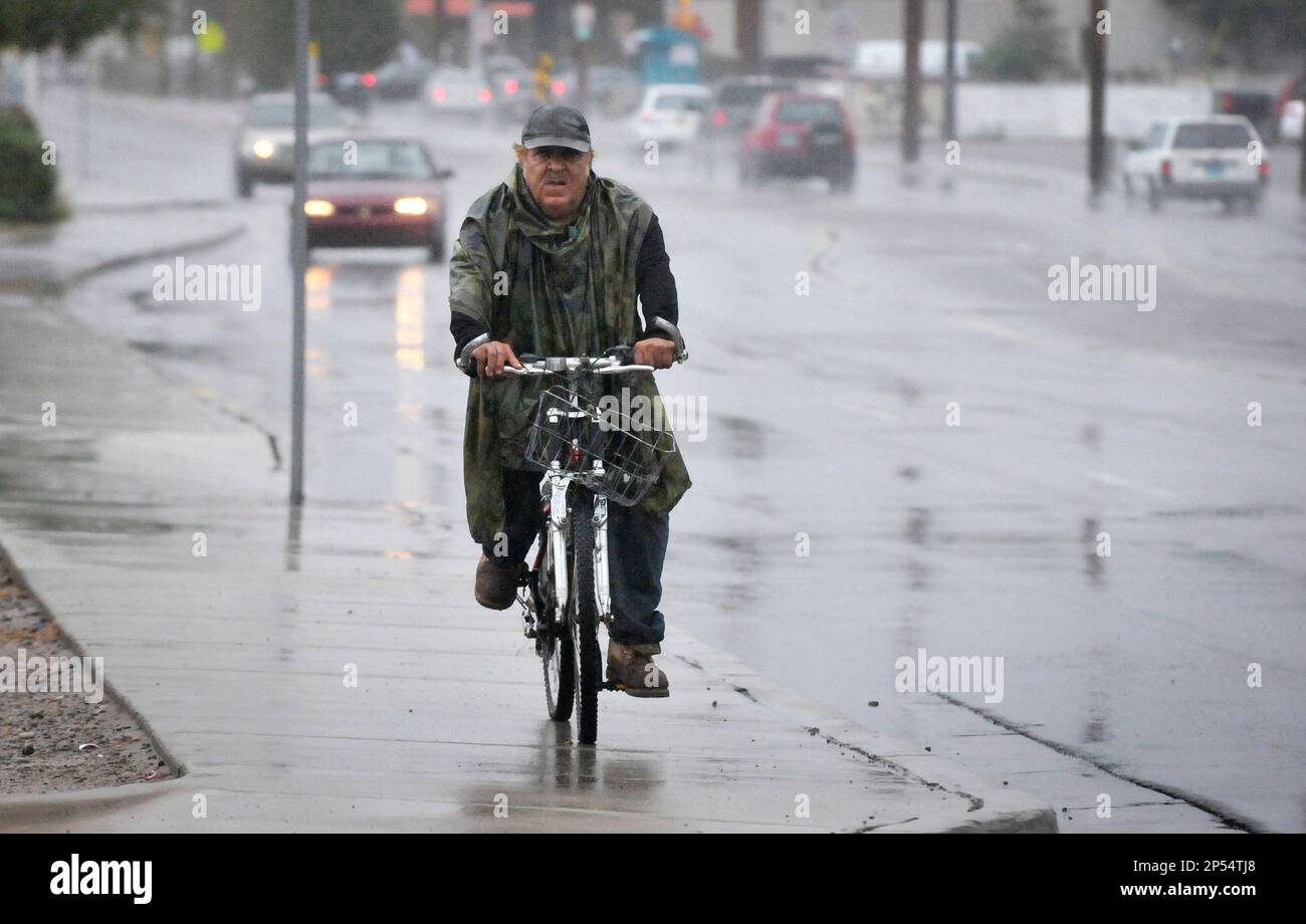 Charles Herrera rides his bicycle in the rain on Fourth Street in the North Valley, during a rain storm, Thursday, Sept. 12, 2013, in Albuquerque, N.M. The New Mexico National Guard and other rescue crews evacuated dozens of campers and residents who were stranded by floodwaters along the Pecos River as New Mexico was drenched Thursday by another round of record rainfall.(AP Photo/The Albuquerque Journal, Marla Brose) THE SANTA FE NEW MEXICAN OUT; MANDATORY CREDIT Banque D'Images
