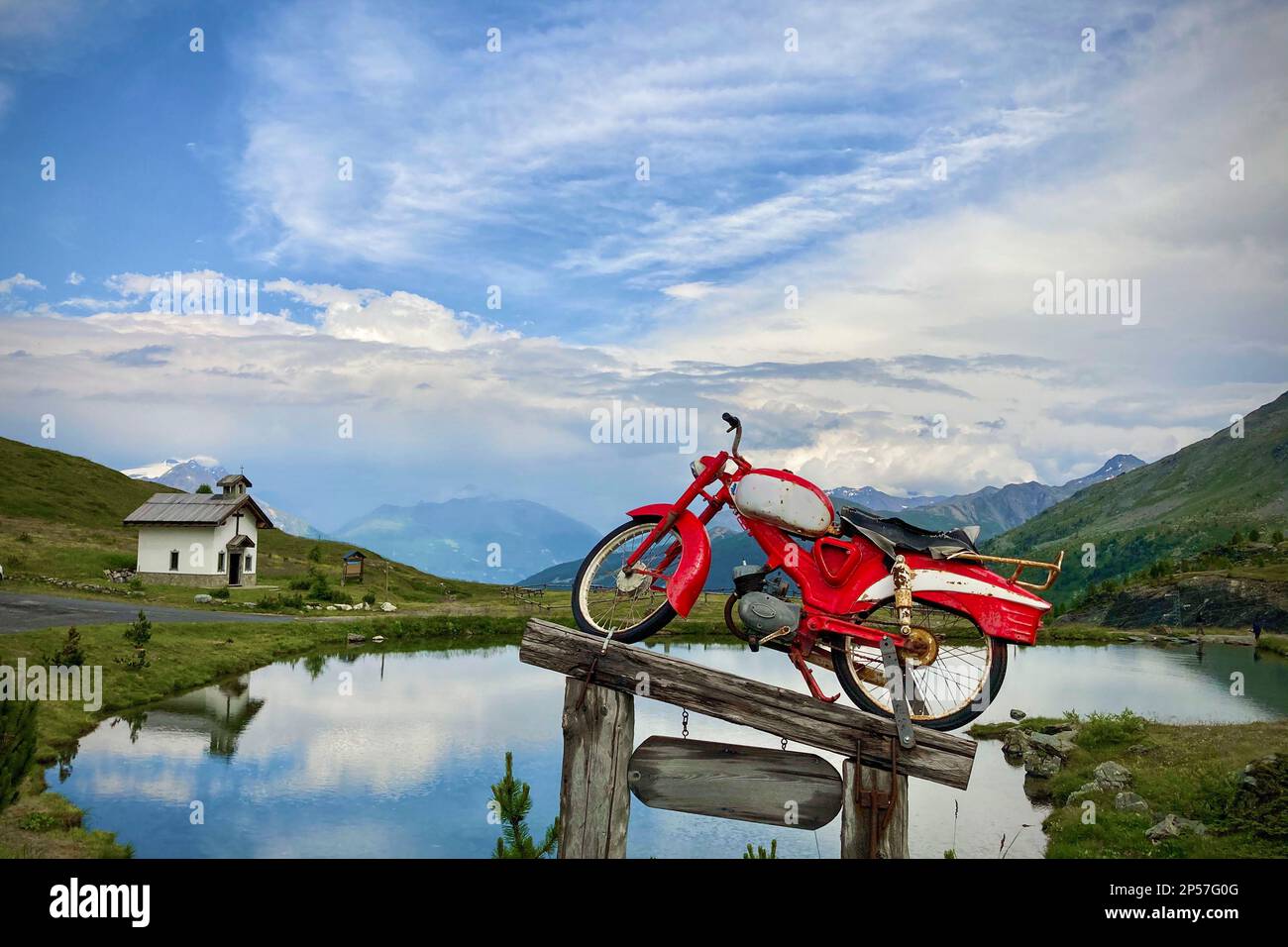 Vieille moto sur un podium en bois, le fond est le ciel bleu avec des nuages. Livigno, Alpes, Italie Banque D'Images