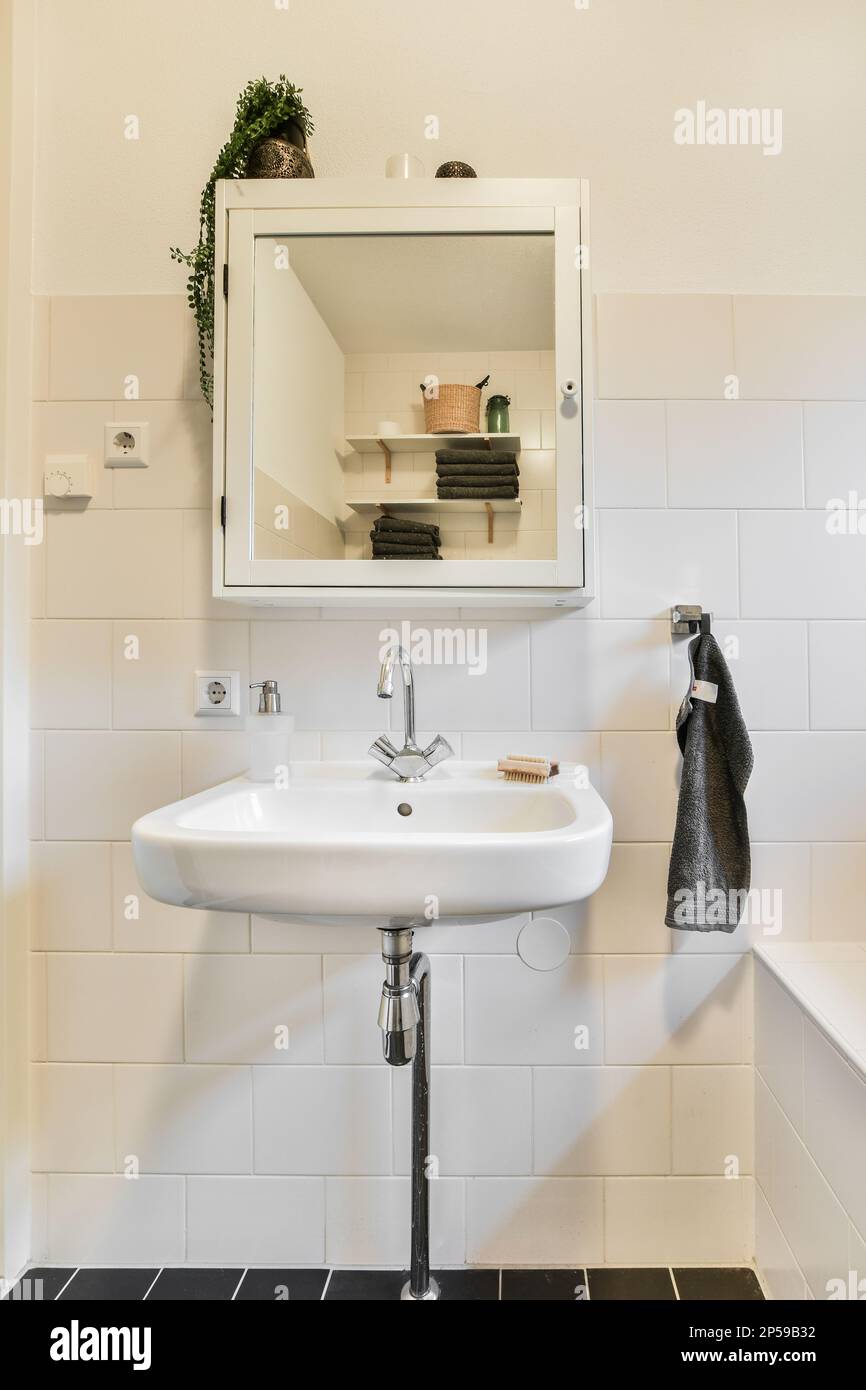 une salle de bains avec un lavabo, un miroir et une serviette accrochée au  mur devant le lavabo est noire et blanche Photo Stock - Alamy