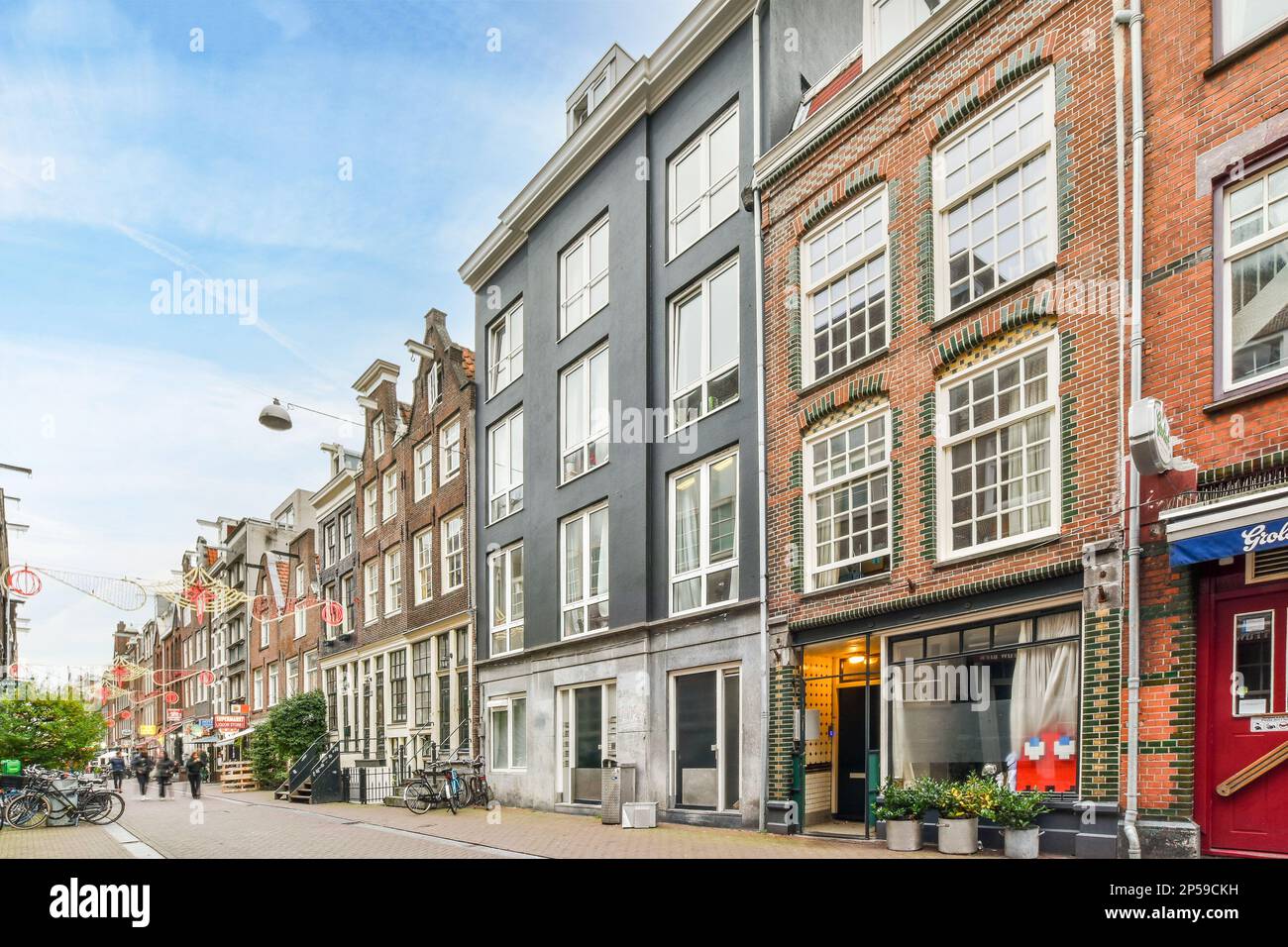 Amsterdam, pays-Bas - 10 avril 2021 : rue de la ville avec des bâtiments des deux côtés et des vélos garés dans les allées le long de la route Banque D'Images