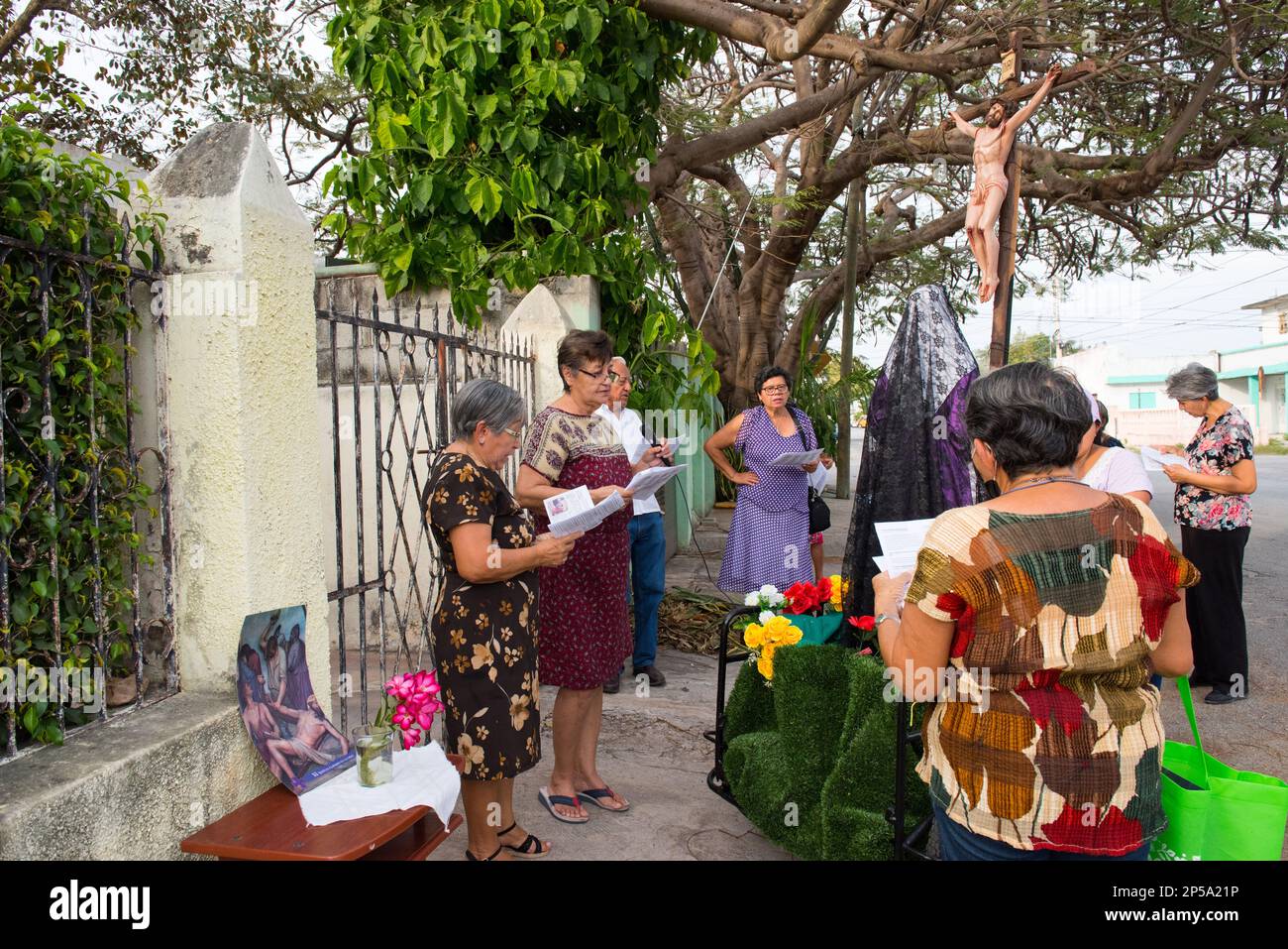 Pour marquer le septième vendredi de Carême, de petits autels d'homme sont établis dans certains des quartiers plus traditionnels de Merida, au Mexique. Ils sont ici pour commémorer la souffrance de la Vierge Marie. Les paroissiens vont de maison en maison avec une statue de la Vierge Marie et une croix avec Jésus, ils prient et chantent des cantiques religieux pour l'occasion Banque D'Images