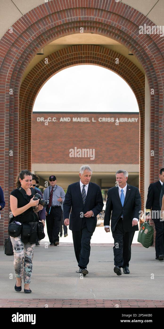 Defense Secretary Chuck Hagel, left, walks across the campus of his alma mater, the University of Nebraska at Omaha, with Nebraska Governor, Dave Heineman, right. Secretary Hagel was on his way to speak in the Omaha, Neb., University's Strauss Performing Arts Center on Wednesday, June 19, 2013. (AP Photo/The Omaha World-Herald, Kent Sievers) MAGS OUT; ALL NEBRASKA LOCAL BROADCAST TV OUT Banque D'Images