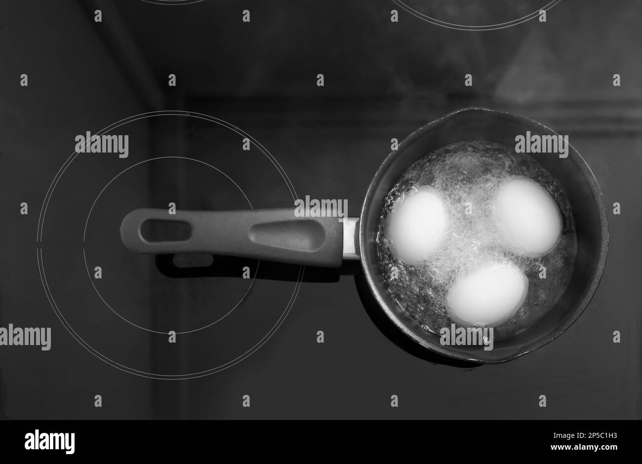 Cuisinière avec œufs bouillonnant dans la cuisine, vue sur le dessus Banque D'Images