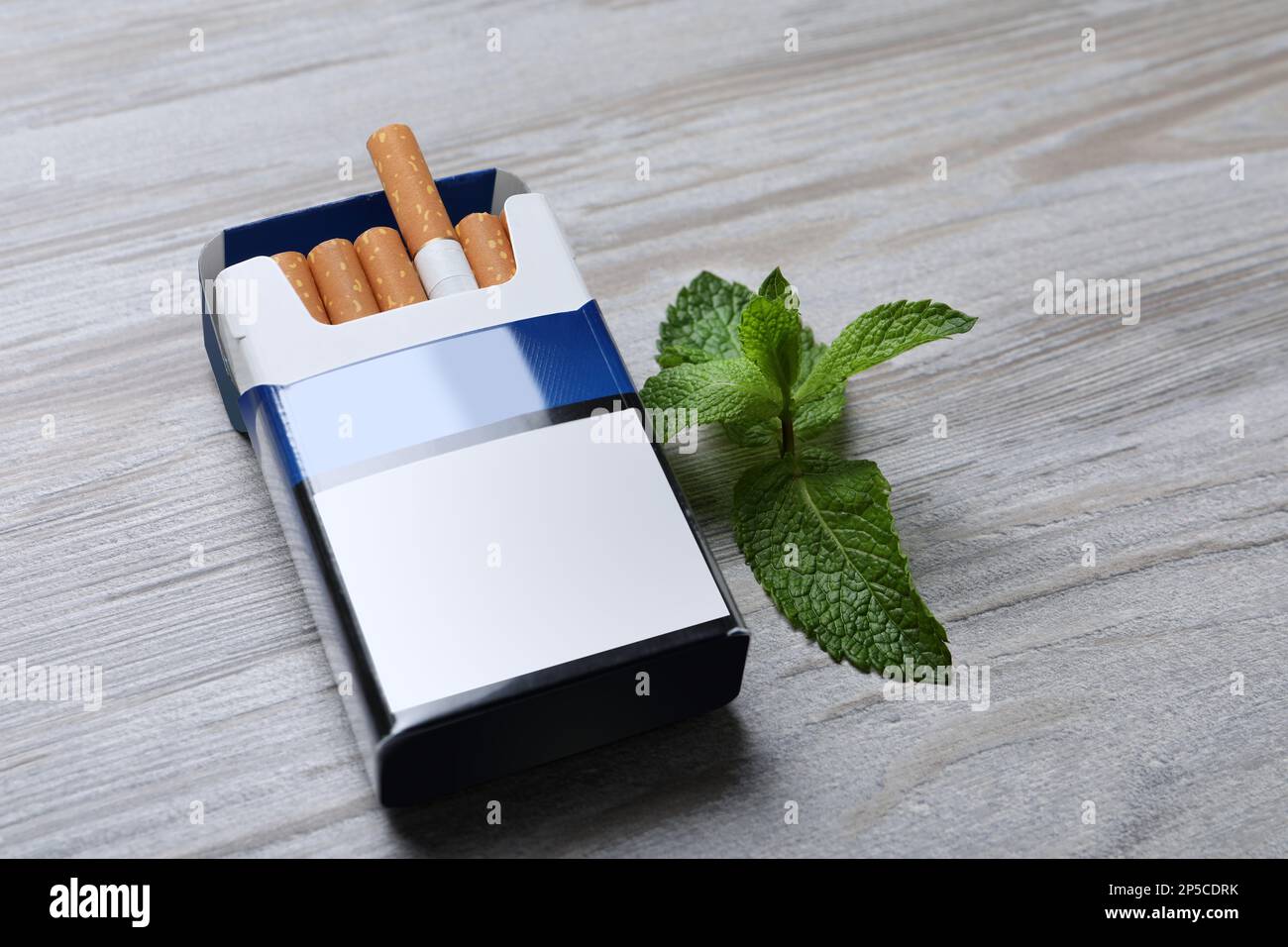 Paquet de cigarettes de menthol et de menthe sur une table en bois clair Banque D'Images