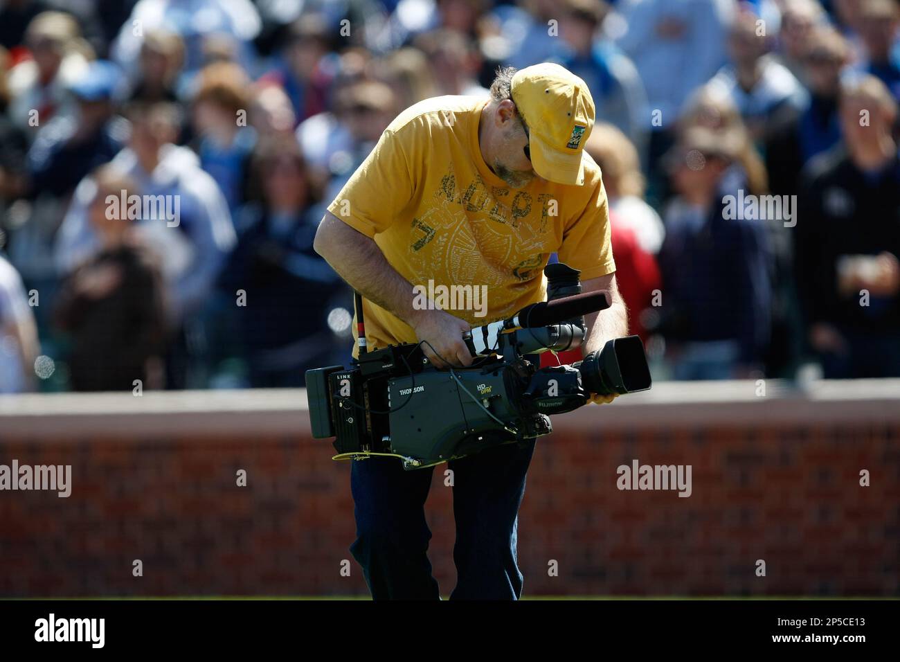 CHICAGO, IL - APRIL 18: A TV cameraman holds a camera as he walks on the field during the game between the Houston Astros against the Chicago Cubs at Wrigley Field on April 18, 2010 in Chicago, Illinois. The Astros defeated the Cubs 3-2 in 10 innings. (AP Photo/Scott Boehm) Banque D'Images